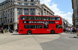 A bus being driven through a city centre. When people do not use the road appropriately and cause an injury, it could give rise to bus and coach compensation claims