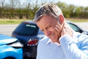 Man holding his neck after experiencing whiplash