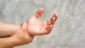 Person holding their injured hand after an accident