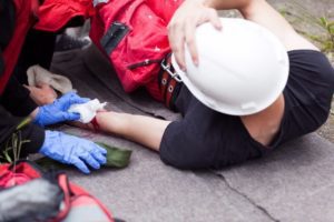 Man with a bleeding wrist being examined by a rescue service