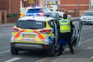 A police officer getting out of a police car.