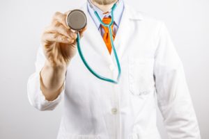 A doctor holds a stethoscope to the screen. 