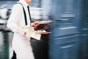 Waiter holding too many plates