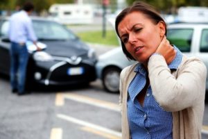 Woman in pain holds neck following a car park accident