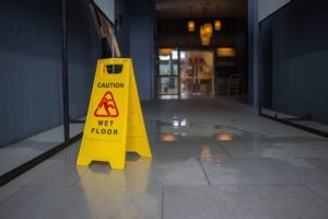 Wet floor caution sign in front of a spillage