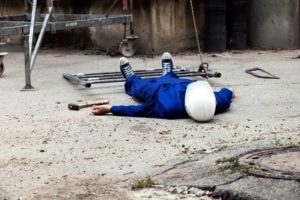 A man lying down on concrete following a defective equipment injury. 