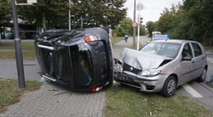 A car crash in the middle of a walkway leaving two cars totalled due to dangerous driving