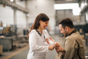 A female doctor treats a worker for a minor injury at work