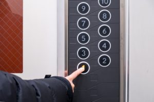 Person selecting the number 1 on an lift control panel