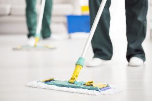 Two cleaners mopping the floor to prevent a slip accident