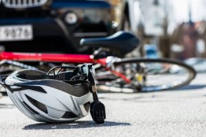 Bicycle and helmet lying on the ground after a cyclist was hit by a car