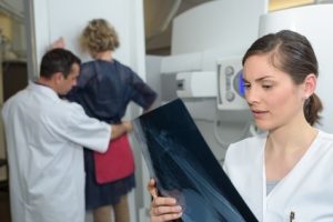 A nurse examines an x-ray result