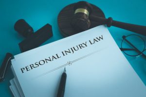 Paperwork titled 'personal injury law' sat on a desk and with a pen on top of it