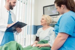 A patient receiving care from a doctor and a nurse in a hospital