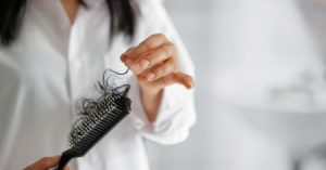 Person picking out hair lost from a comb