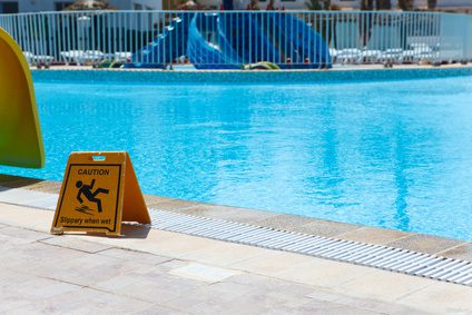 a swimming pool with a warning sign in front of it