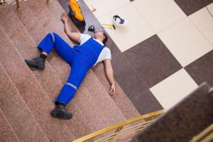 a man lying on the ground after falling down stairs at work