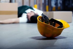 Employee lying on the floor of a warehouse after a forklift accident. 