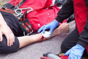 A negligent first aider applying a gauze to a wounded worker