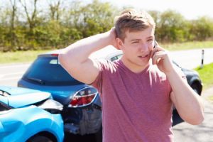 Man calling his insurance after getting hit by an uninsured driver