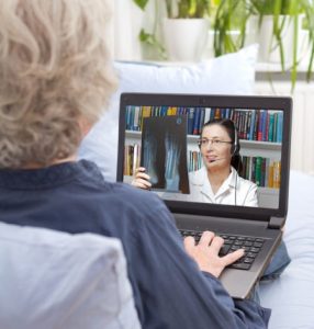 Patient using laptop to receive online consultation from a doctor