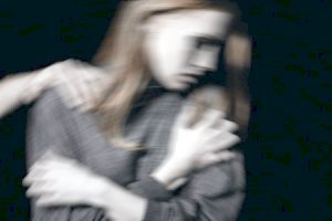 Blurry image of a woman looking away as she's getting grabbed by someone