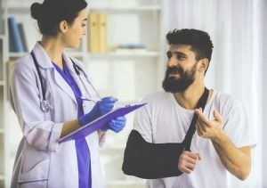 Doctor Takes Notes From A Man With A Broken Arm. 