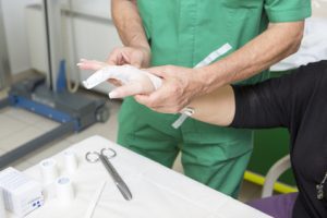 Doctor touching a patient's hand which had an avulsion fracture