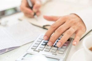 Person using a compensation table and calculator in order to work out the value of a personal injury claim