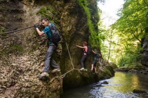 People enjoying a mountain climb next to water at an outdoor activity centre