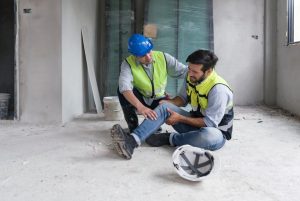 Man getting help after straining his leg after an accident at work