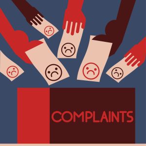 lots of different hands putting in paper with unhappy faces into a box labelled complaints
