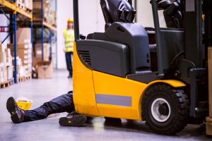 a man lays unconscious on the floor after being hit by a forklift truck