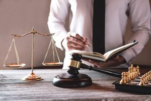 Chess board, notebook, gavel and lawyer reading his notes