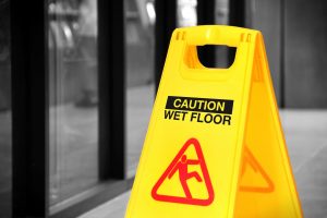 Bright yellow wet floor sign in a hallway