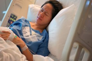 A mother suffering with birth injuries in a hospital bed. 