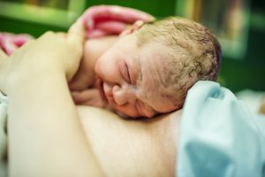 New born baby in mother's arms. 