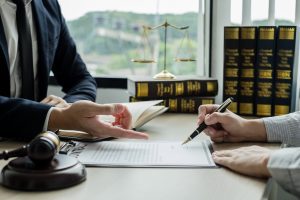 A lawyer asks a client to sign a contract.