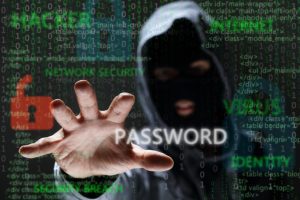 An individual in a grey hoodie and black face mask reaching for the word 'password.'