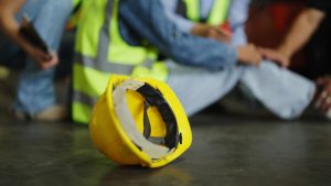 A man sitting on the ground following a faulty equipment injury. 