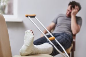 A man with a broken leg in a cast looks out the window