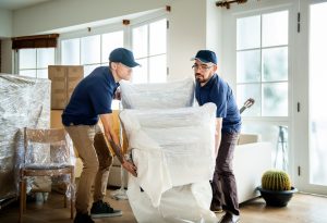 Two men lifting and carrying a broken chair