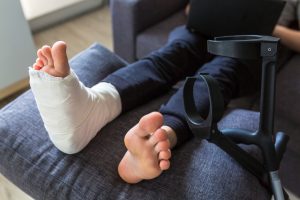 An injured foot wrapped in a bandage and resting on a pillow after a deep puncture wound