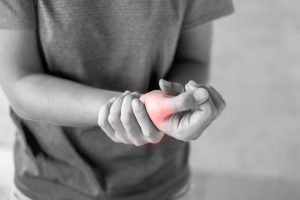 A person holds their wrist, having suffered a wrist injury.