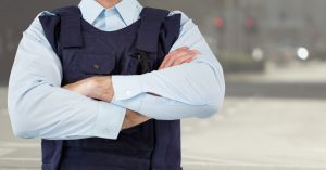 A prison staff member with his arms crossed over his chest. 