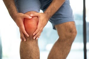 A person holds a dislocated knee.