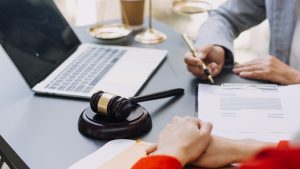 A solicitor writes down examples of medical negligence payouts for a client.