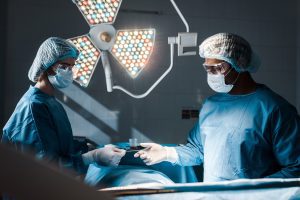 Two surgeons perform surgery in a hospital.