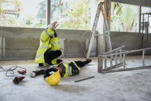 An injured worker has fallen from a ladder, their colleague calls for help. 