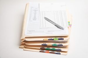 A stack of medical records, organised by colour and number. 